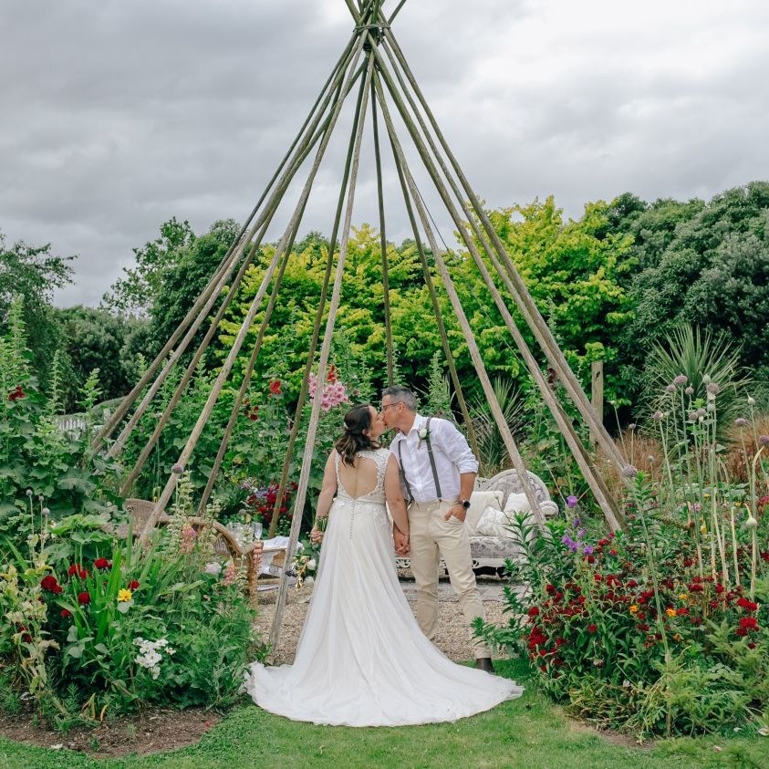 bride and room share a moment in under the Rosebrooke Gardens teepee.