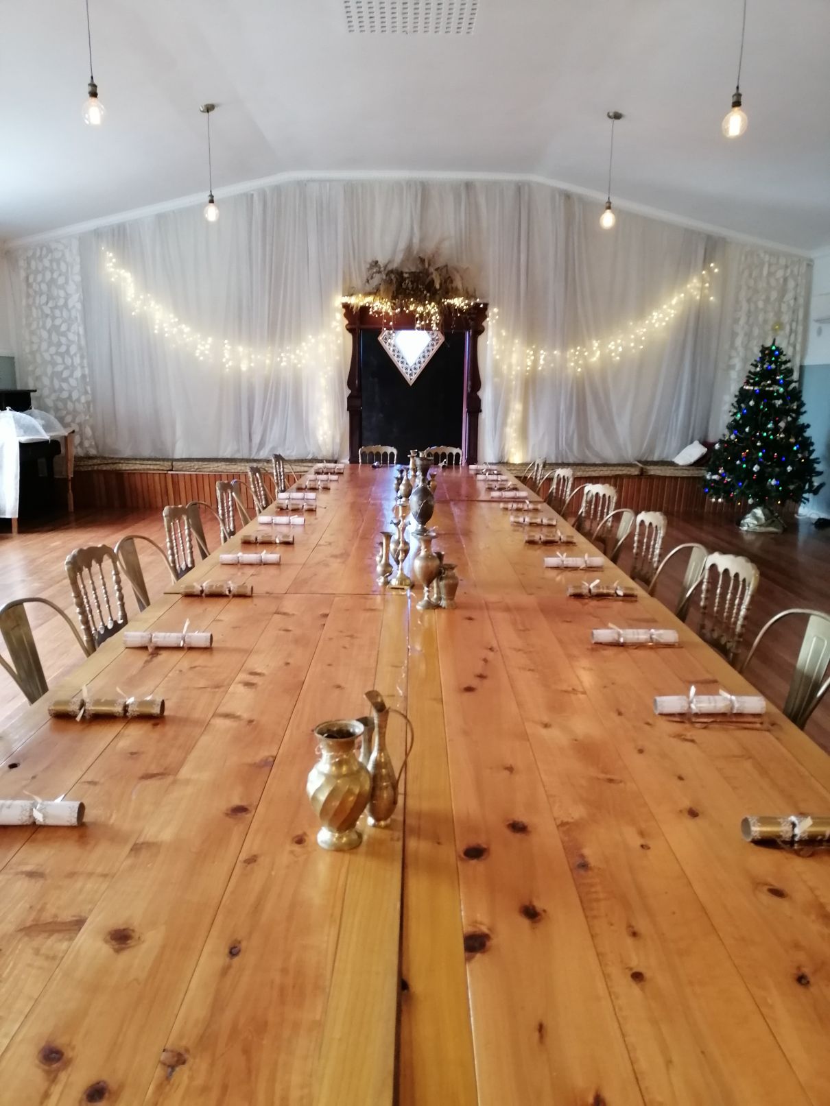 a large table is set up in the Rosebrooke hall with a christmas tree in the corner.