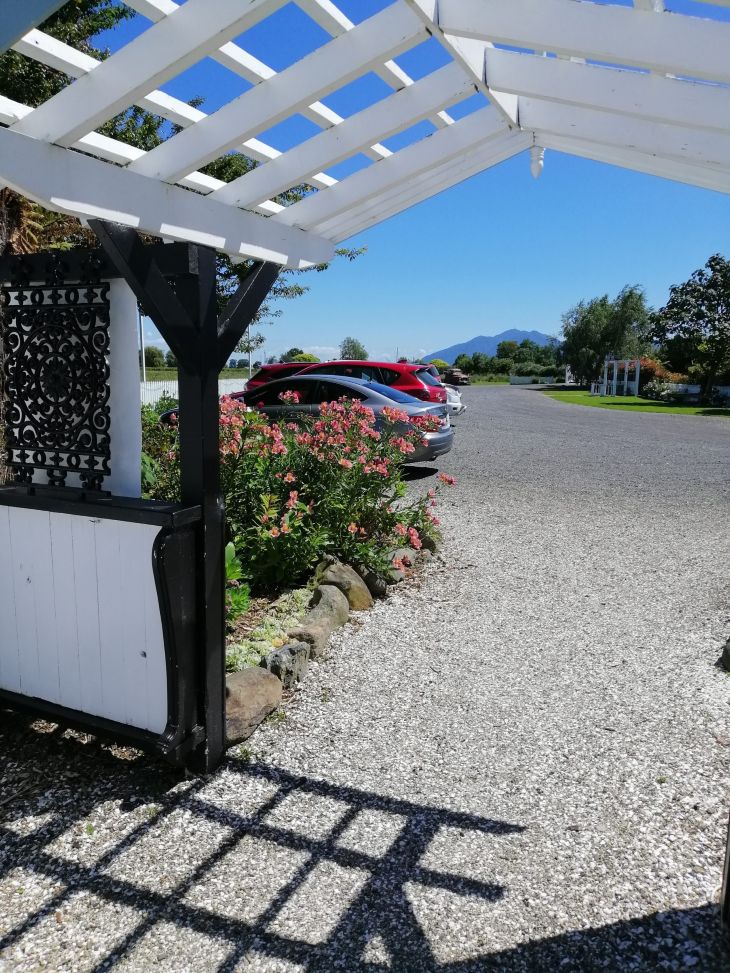 View of the Rosebrooke carpark through the courtyard entrance archway looking towards Mount Te Aroha.